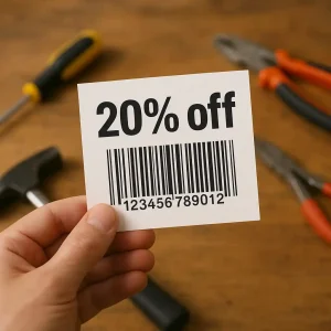 Hand holding a printed 20 percent off Home Depot coupon printable over a wooden workbench with tools